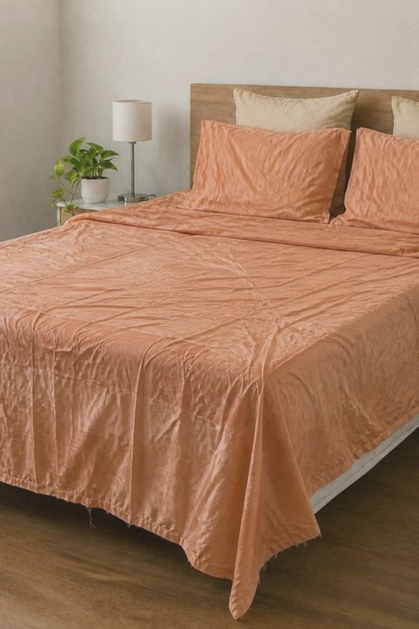 The faded peach bedsheet that arrived, shiny cheap fabric with wrinkles and loose threads